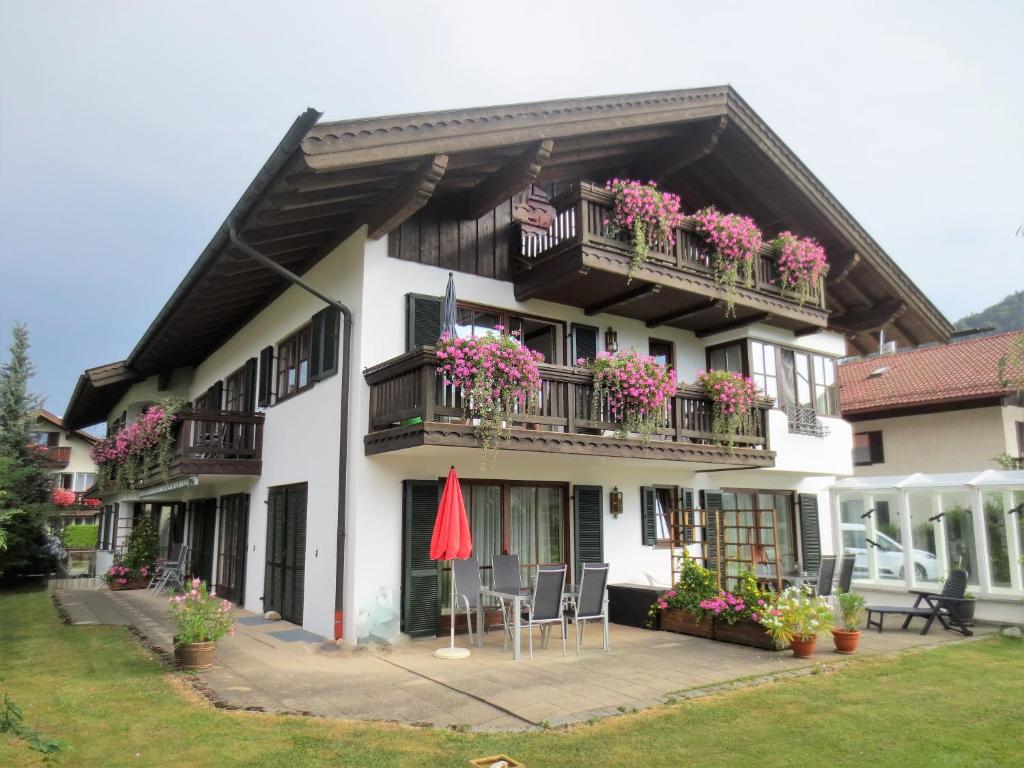 um edifício com flores nas varandas e uma bandeira americana em Hotel Rosenhof em Ruhpolding