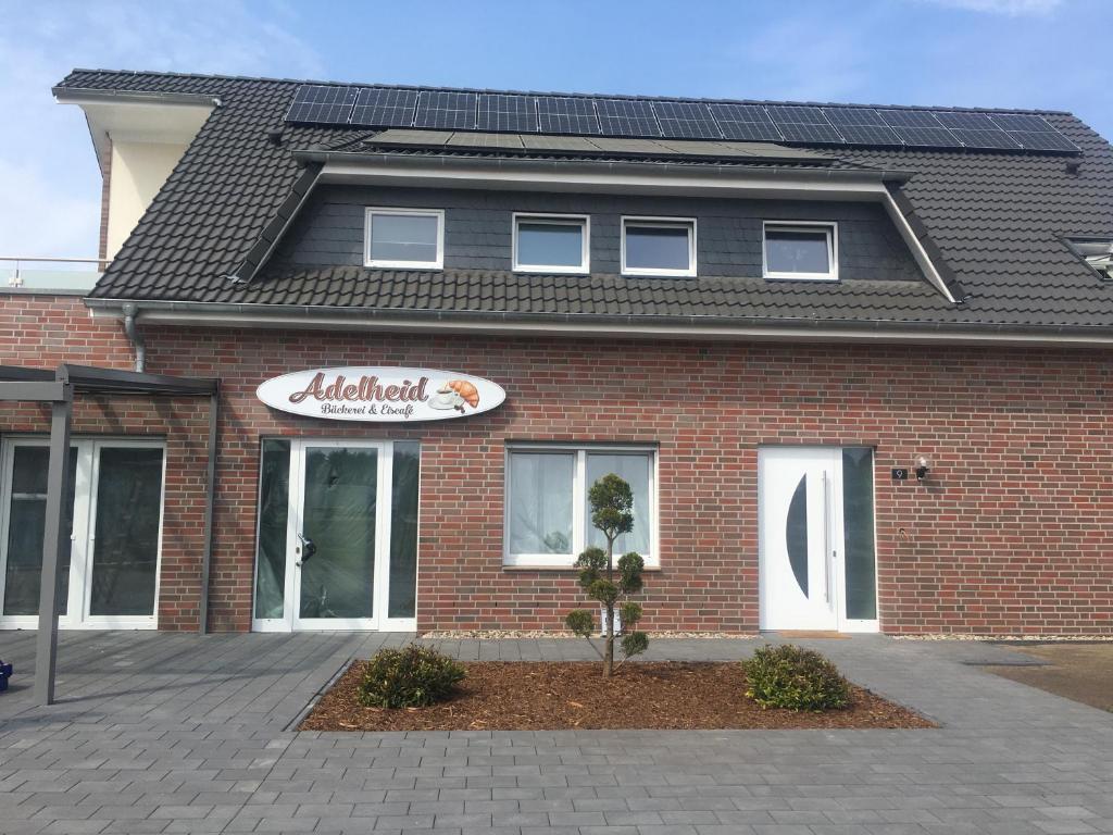 a red brick building with a sign on it at Gäste und Messezimmer Adelheidsdorf in Adelheidsdorf