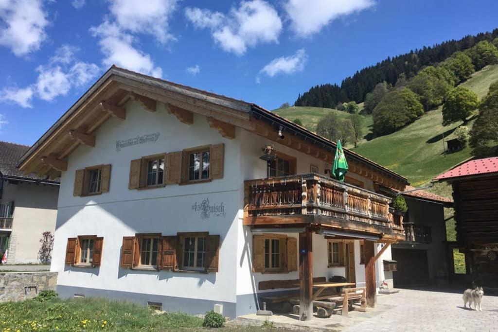 a house in the mountains with a balcony at Ferienwohnung Uf Z`Enisch in Klosters