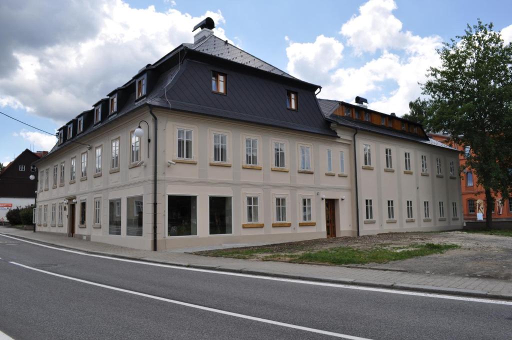 ein großes weißes Gebäude an der Straßenseite in der Unterkunft Penzion Lípa in Krásná Lípa