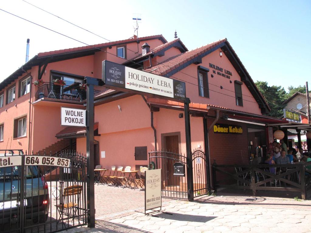 a building with a sign in front of it at Holiday Łeba in Łeba