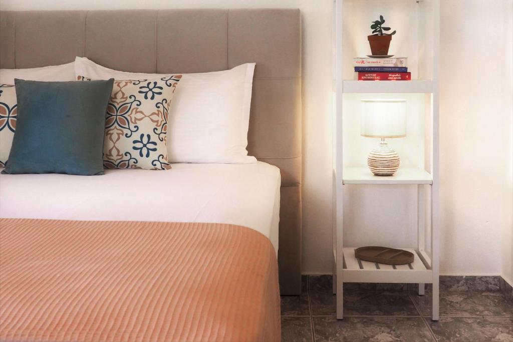 a bedroom with a bed and a nightstand with a lamp at Olive House in Malia