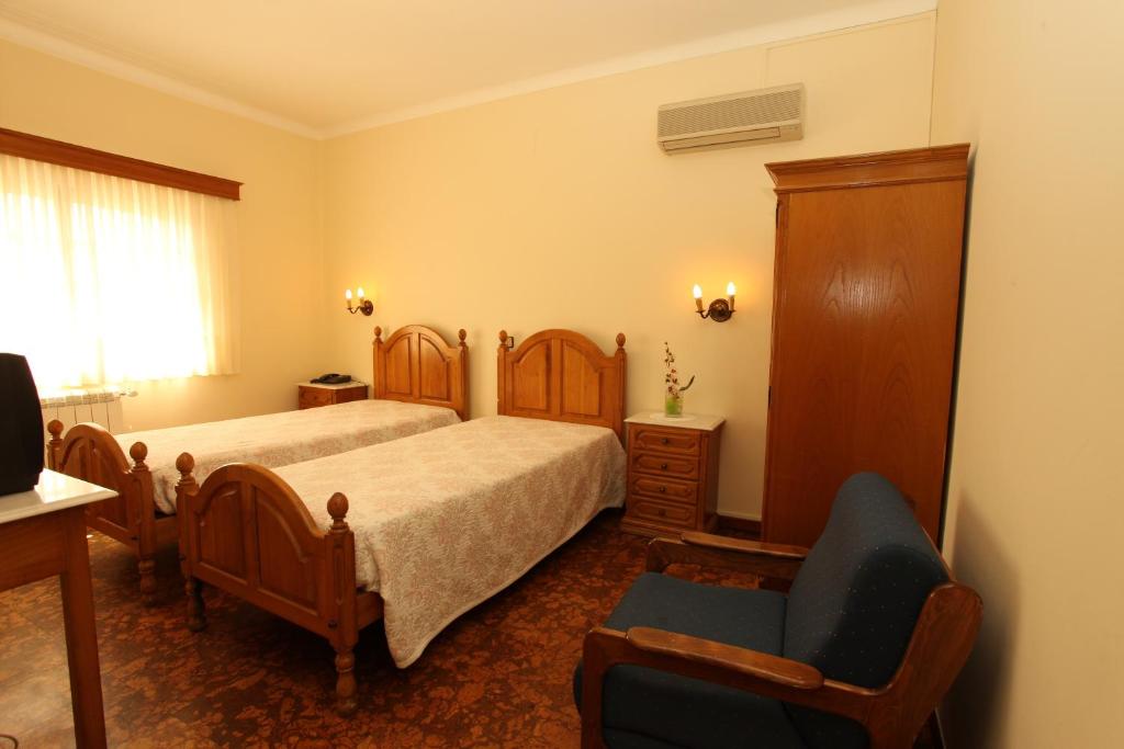 - une chambre avec un lit et une chaise dans l'établissement Residencial Sra. da Lomba, à Pinhanços