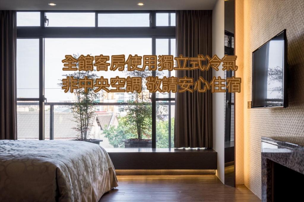 um quarto com um lustre em frente a uma janela em Ai Ni Ya Motel em Beigang