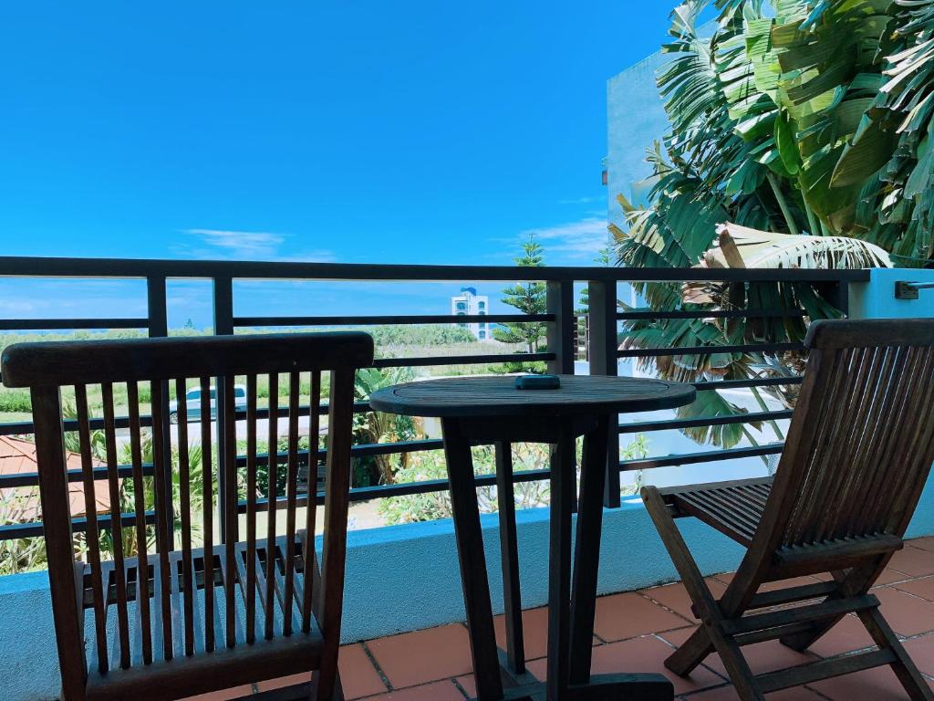 a table and chairs on a balcony with a view of the ocean at Ibali Hostel in Magong