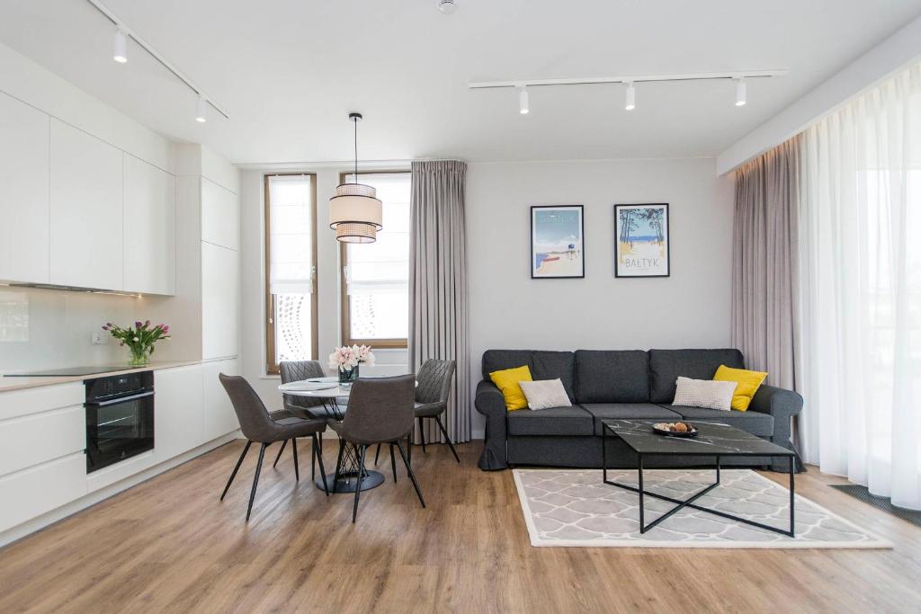 ein Wohnzimmer mit einem Sofa und einem Tisch in der Unterkunft Yellow Rentyear Apartments in Danzig