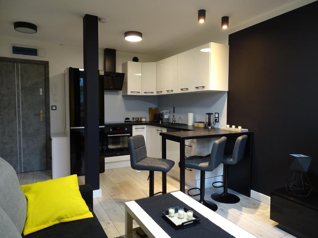 a kitchen and living room with a table and chairs at No71 The Luxury Apartment in Głogów