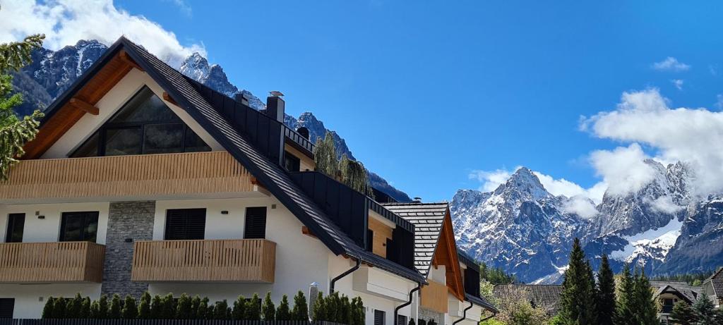 un edificio con montañas en el fondo en Vila Mojca Apartments Jasna & Jelka, en Kranjska Gora