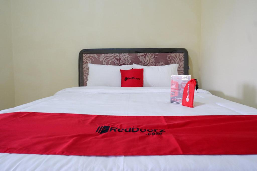 Una cama con una caja roja encima. en RedDoorz near Lippo Plaza Buton en Baubau