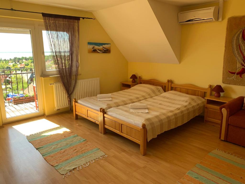 sypialnia z łóżkiem i dużym oknem w obiekcie HolidaySport Haus w mieście Balatongyörök
