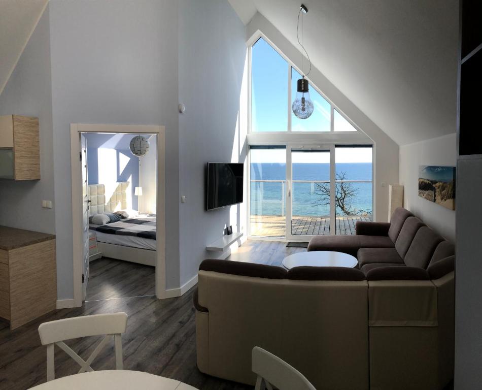 a living room with a couch and a view of the ocean at Amber Cliff in Mechelinki