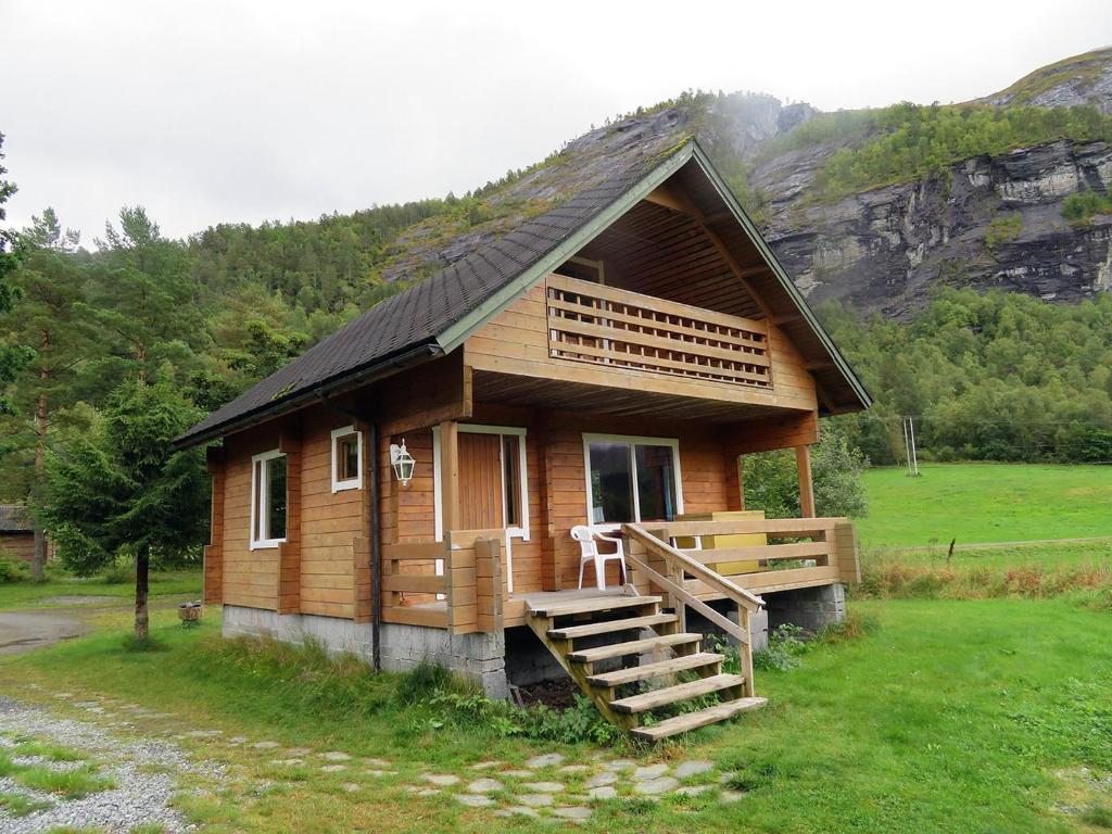 Cabaña de madera pequeña con porche y escalera en Kalvatn Turistsenter en Austefjorden
