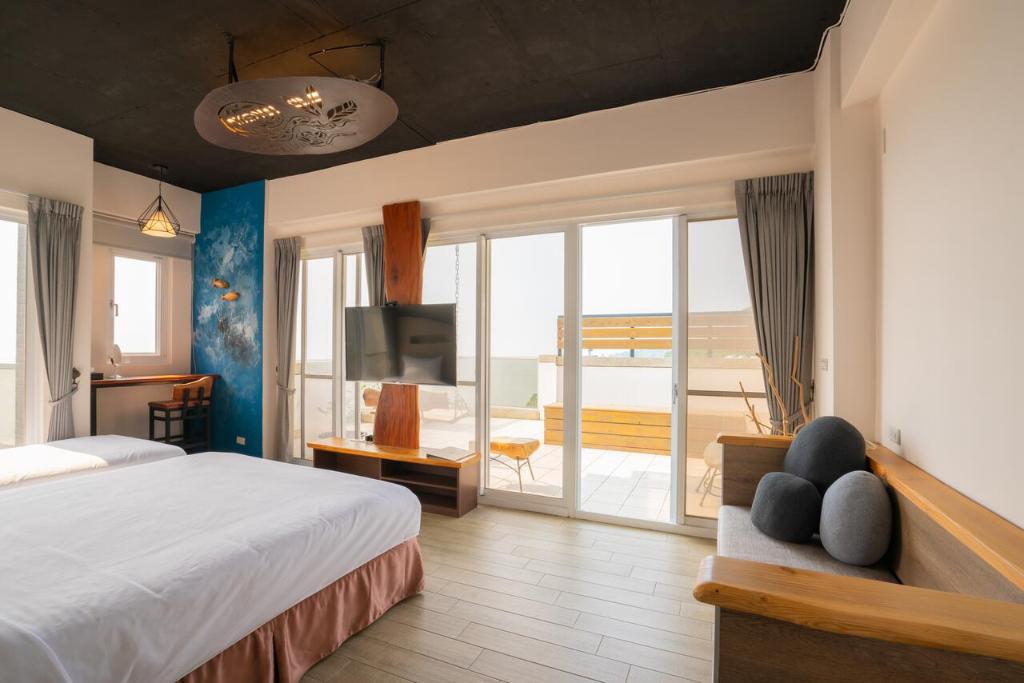 een slaapkamer met een bed en uitzicht op de oceaan bij YUN-JIN Villa Matsu in Nangan