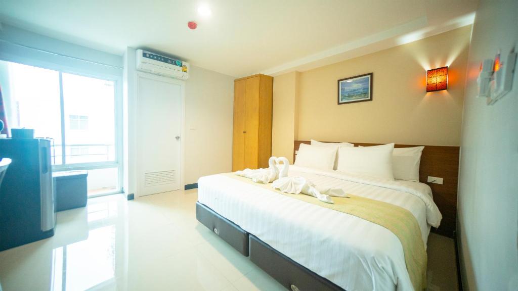 The Willing Hotel and Residence في Lak Si: غرفة فندق عليها سرير وفوط