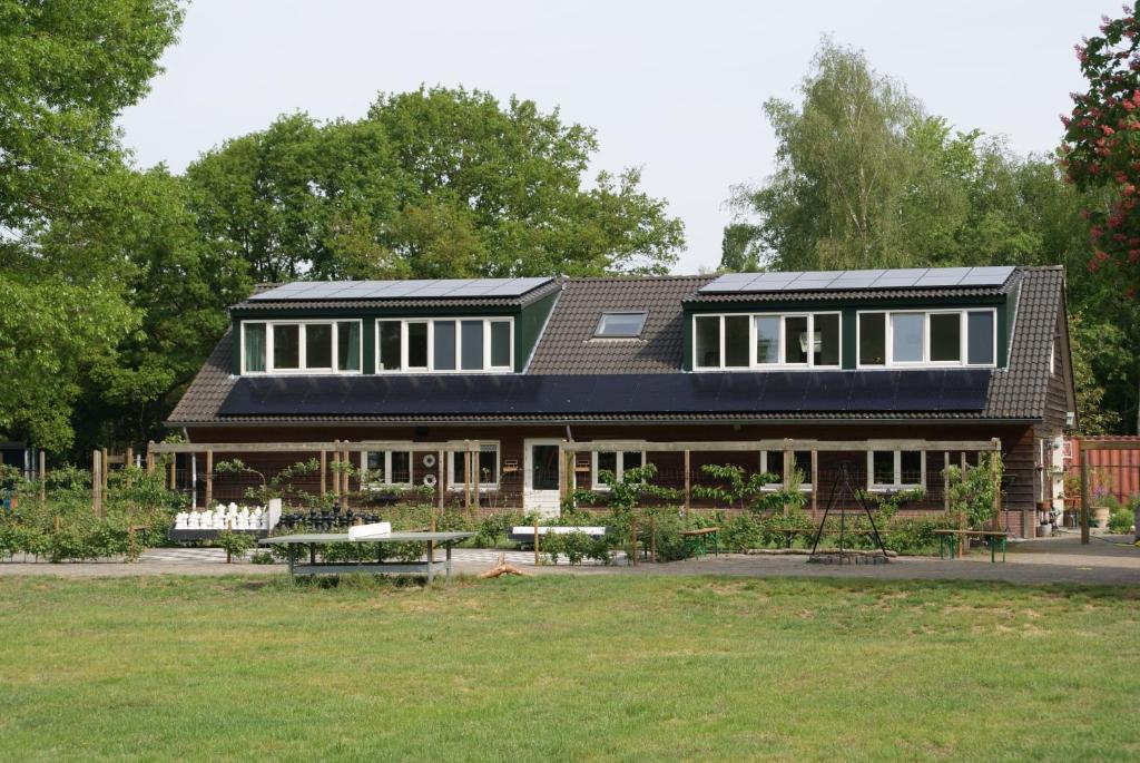 a house with solar panels on top of a yard at Vakantieboerderij 't Zand - Appartement in Heeswijk-Dinther