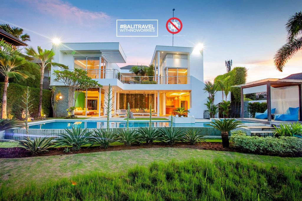 uma casa com piscina e um relógio em Phocea Golf View Villa by Premier Hospitality Asia em Jimbaran