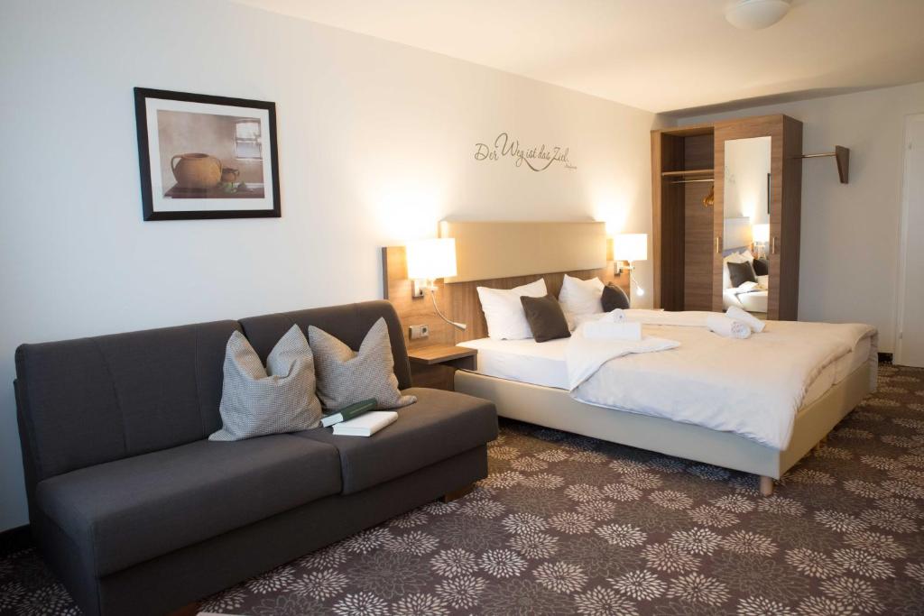 ein Hotelzimmer mit einem Sofa und einem Bett in der Unterkunft Brutsches Rebstock in Laufenburg