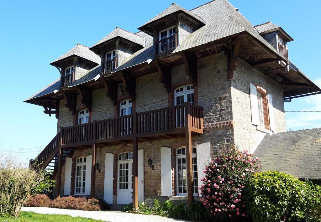 a large house with a gambrel roof at LE CHALET SUISSE - Chambre bleue in Le Vicel