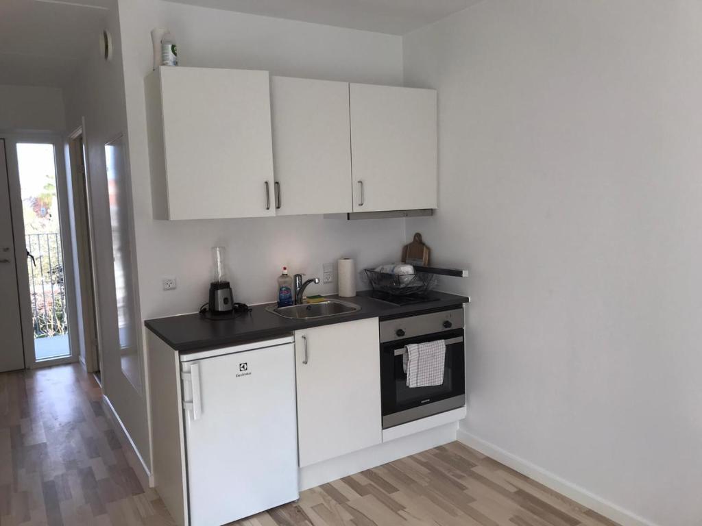 a kitchen with white cabinets and a sink at Amager Studio in Copenhagen