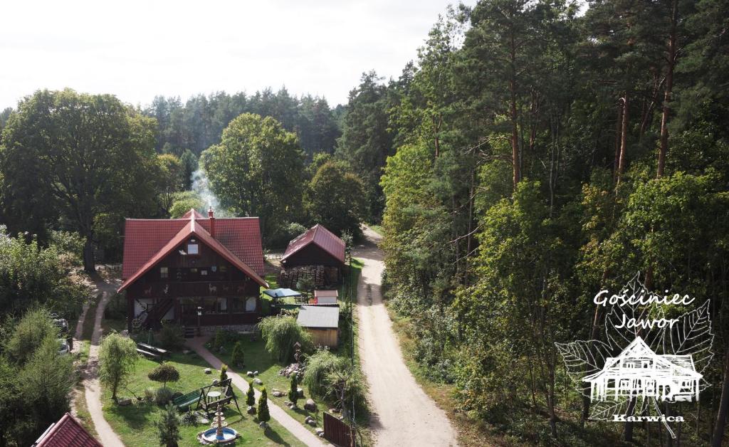 a house in the middle of a forest with a road at Gościniec Jawor in Ruciane-Nida