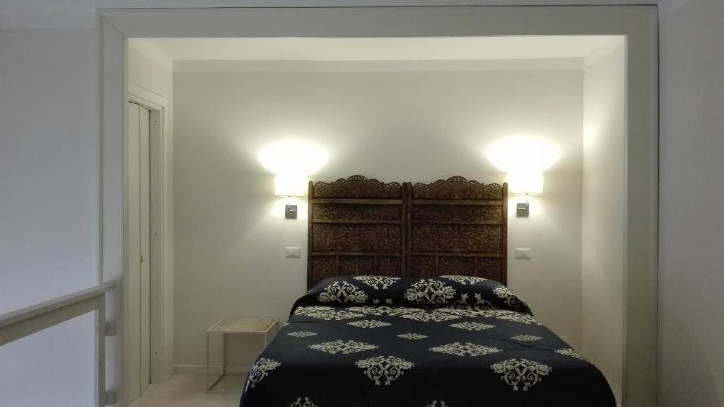 sypialnia z łóżkiem i 2 lampkami na ścianie w obiekcie Piano Nobile w mieście Napoli