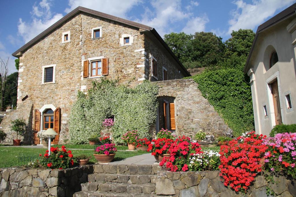 a stone house with flowers in front of it at Convento La Perla in Carrara