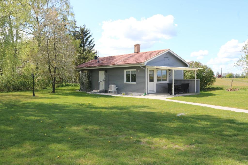 a small house with a lawn in front of it at Kärraton Stugor in Åhus