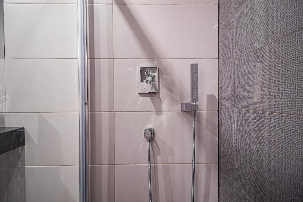 a shower with a glass door in a bathroom at Buganvilias Do Meco Guest house in Sesimbra