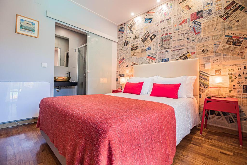 a bedroom with a large bed with red pillows at Buganvilias Do Meco Guest house in Sesimbra