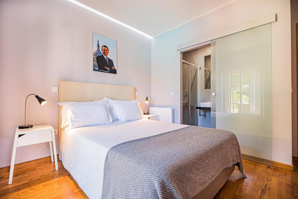 a bedroom with a large bed and a window at Buganvilias Do Meco Guest house in Sesimbra