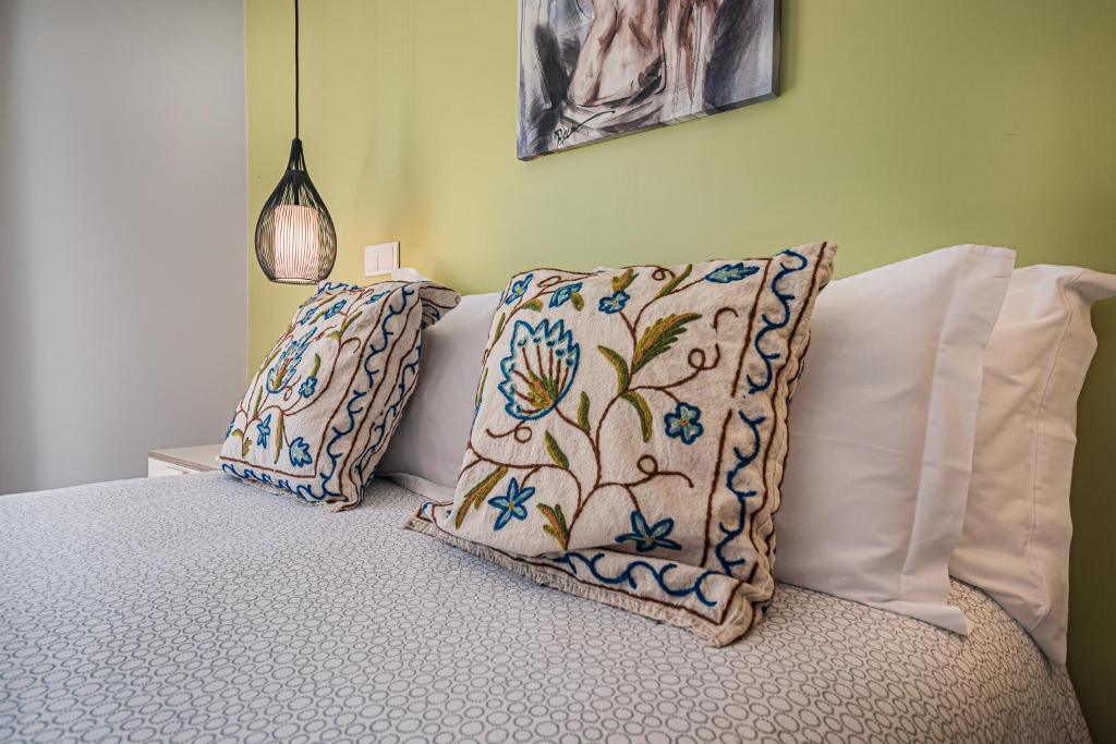 a bed with two pillows on top of it at Buganvilias Do Meco Guest house in Sesimbra