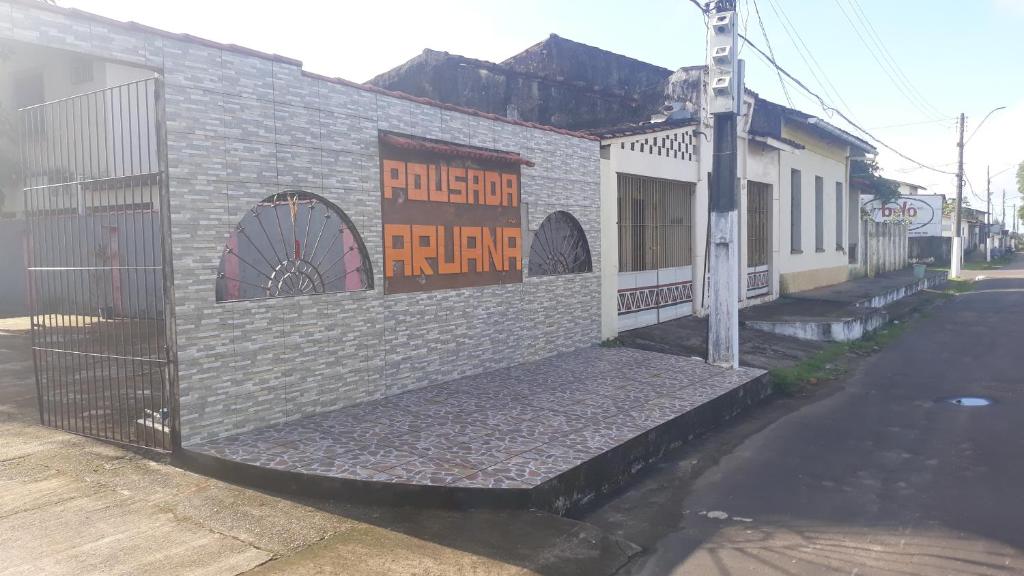 a brick building with a sign on the side of it at Pousada Aruanã in Soure