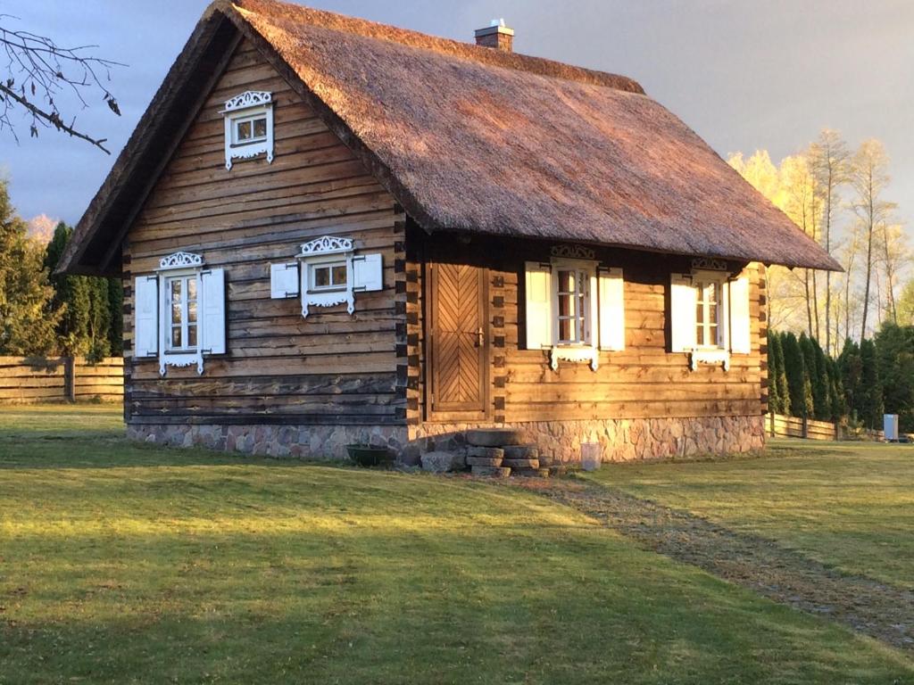 an old log cabin with a grass roof at Baublys Lake Lodge in Viktarinas