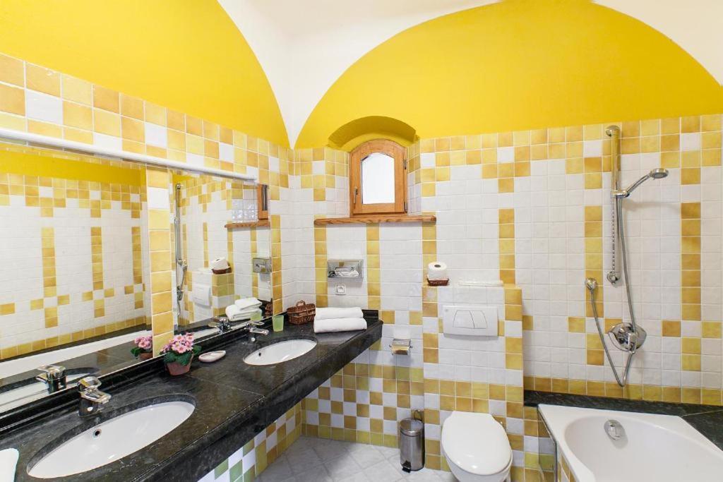 łazienka z 2 umywalkami, toaletą i lustrem w obiekcie Zamek Korzkiew w mieście Korzkiew