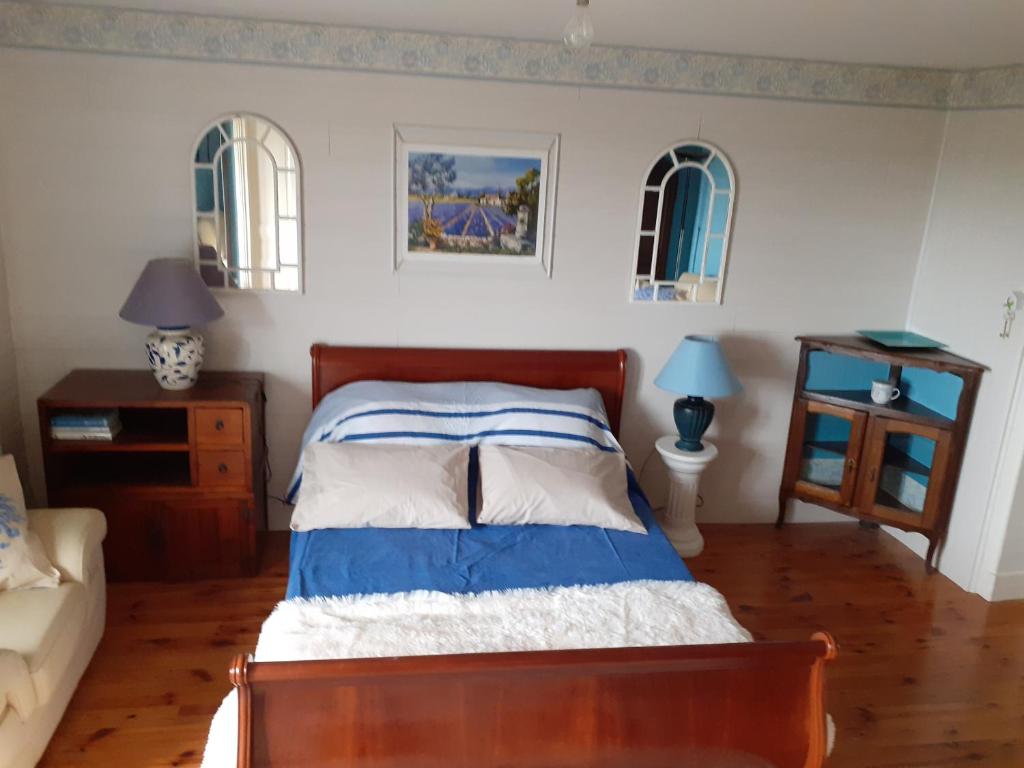 Schlafzimmer mit einem Bett mit blauer und weißer Bettwäsche in der Unterkunft 7042Douce Nuit in Saint-Germain-Laval