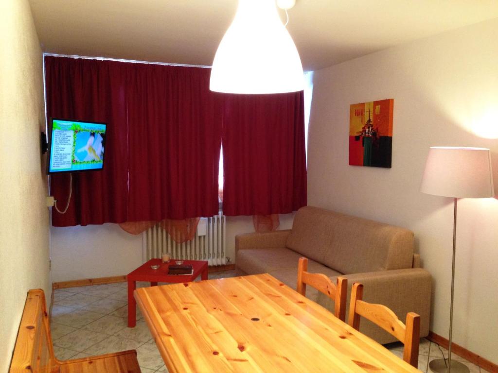 a living room with a wooden table and a couch at Appartamento Marilleva 1400 in Marilleva