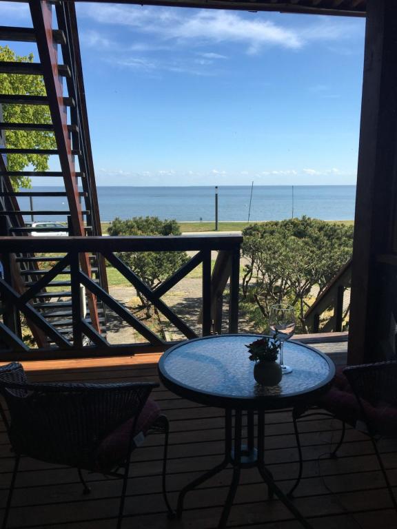 - une table sur un balcon avec vue sur la plage dans l'établissement Curonian Coast studio, à Nido