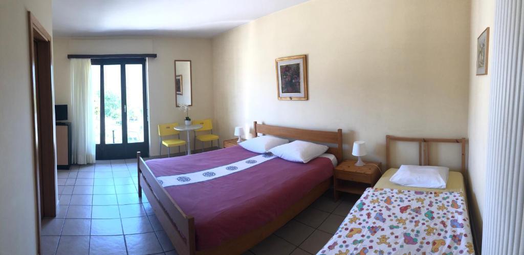Schlafzimmer mit einem Bett, einem Tisch und einem Fenster in der Unterkunft Ristorante Campagna in Cugnasco
