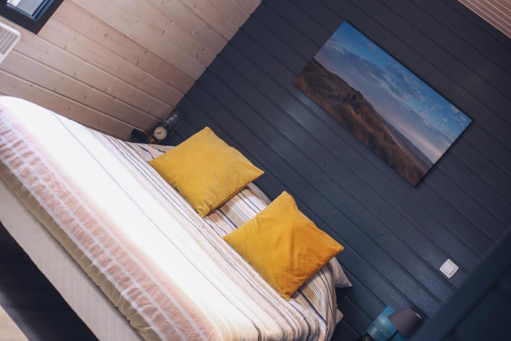 Au Cap Norwoe في سانت كوينتن ان تورمونت: سرير مع وسادتين صفراء في الغرفة
