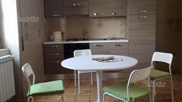 a kitchen with a white table and four chairs at ROOM in Capua