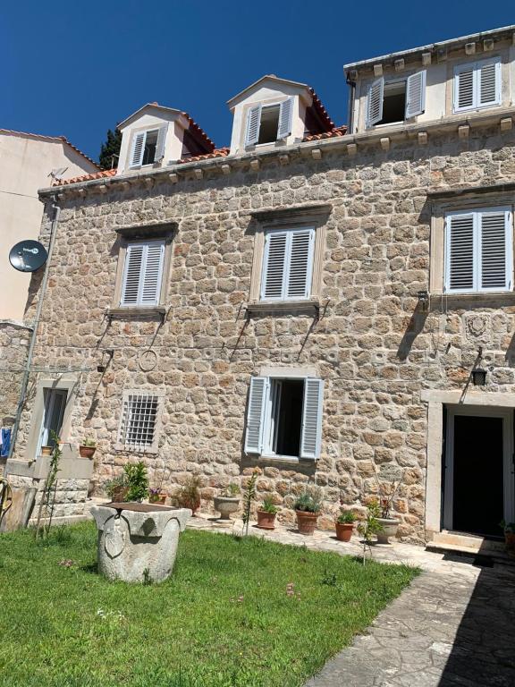 een stenen huis met een bankje ervoor bij Guest House Libertas in Dubrovnik