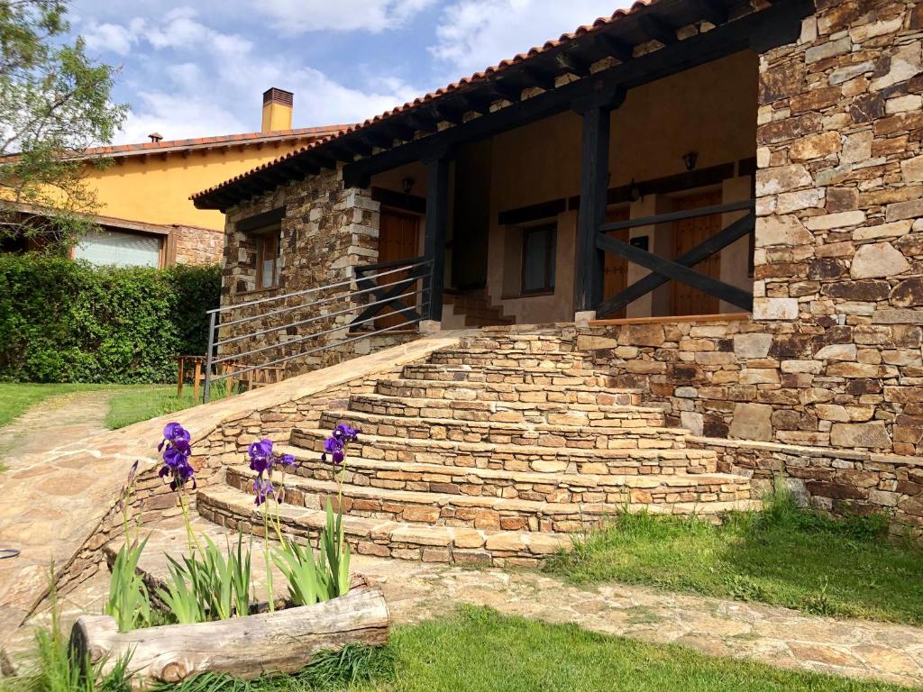 una casa con algunas figuras púrpuras en los escalones en El Hayuco de Montejo en Montejo de la Sierra