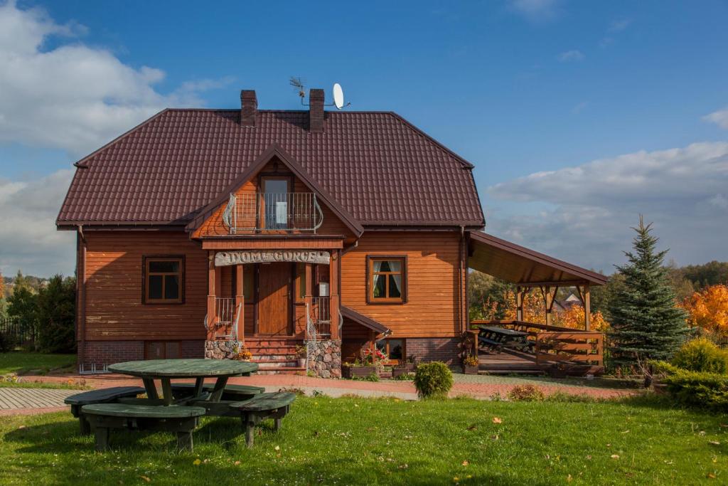 a wooden house with a picnic table in front of it at Dom Gościnny na Górce in Leszczewek