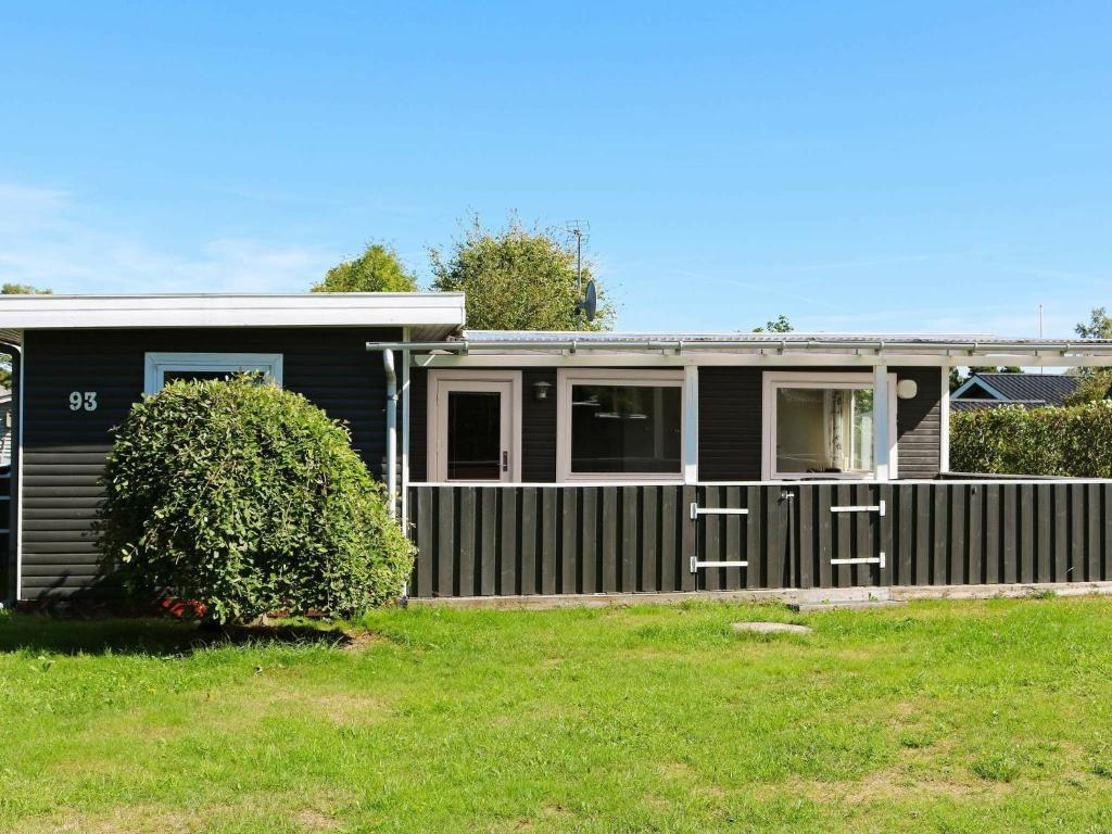 una casa negra con una valla en un patio en 6 person holiday home in Hadsund en Nørre Hurup