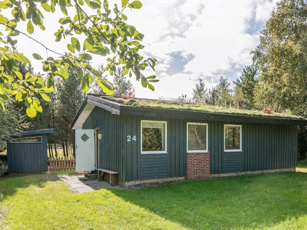 a green shed in a yard with grass at 6 person holiday home in R m in Bolilmark