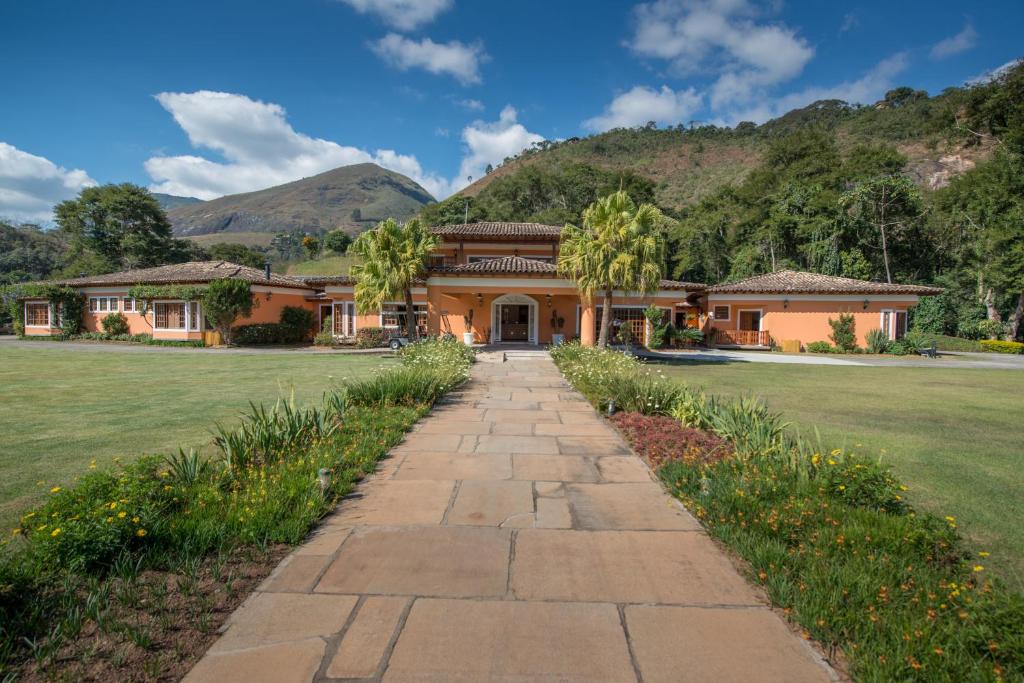 a house with a stone walkway in front of a yard at Quinta da Paz Resort in Itaipava