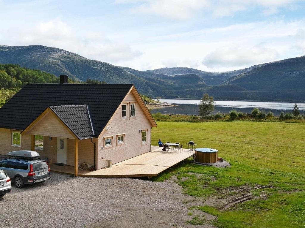 a house with a wooden deck next to a field at 7 person holiday home in Foldereid in Årfor