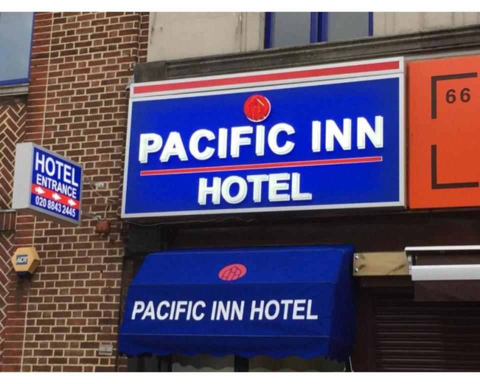 ein Schild für ein Hotel an der Seite eines Gebäudes in der Unterkunft Pacific Inn London Heathrow in Southall
