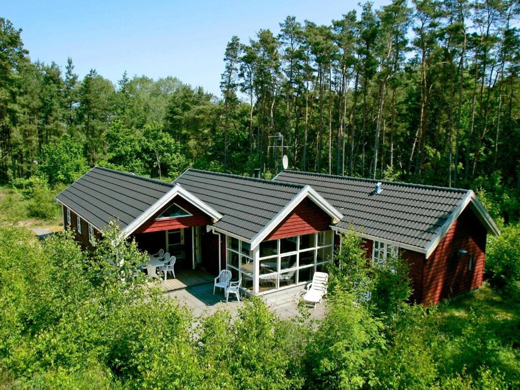 a log cabin in the middle of a forest at Modern Holiday Home in Aakirkeby with Sauna in Vester Sømarken