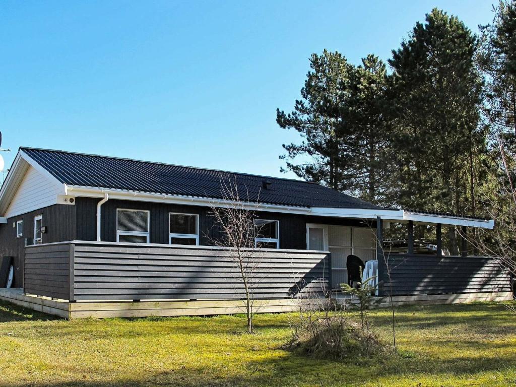a black and white house with a yard at 6 person holiday home in Væggerløse-By Traum in Marielyst